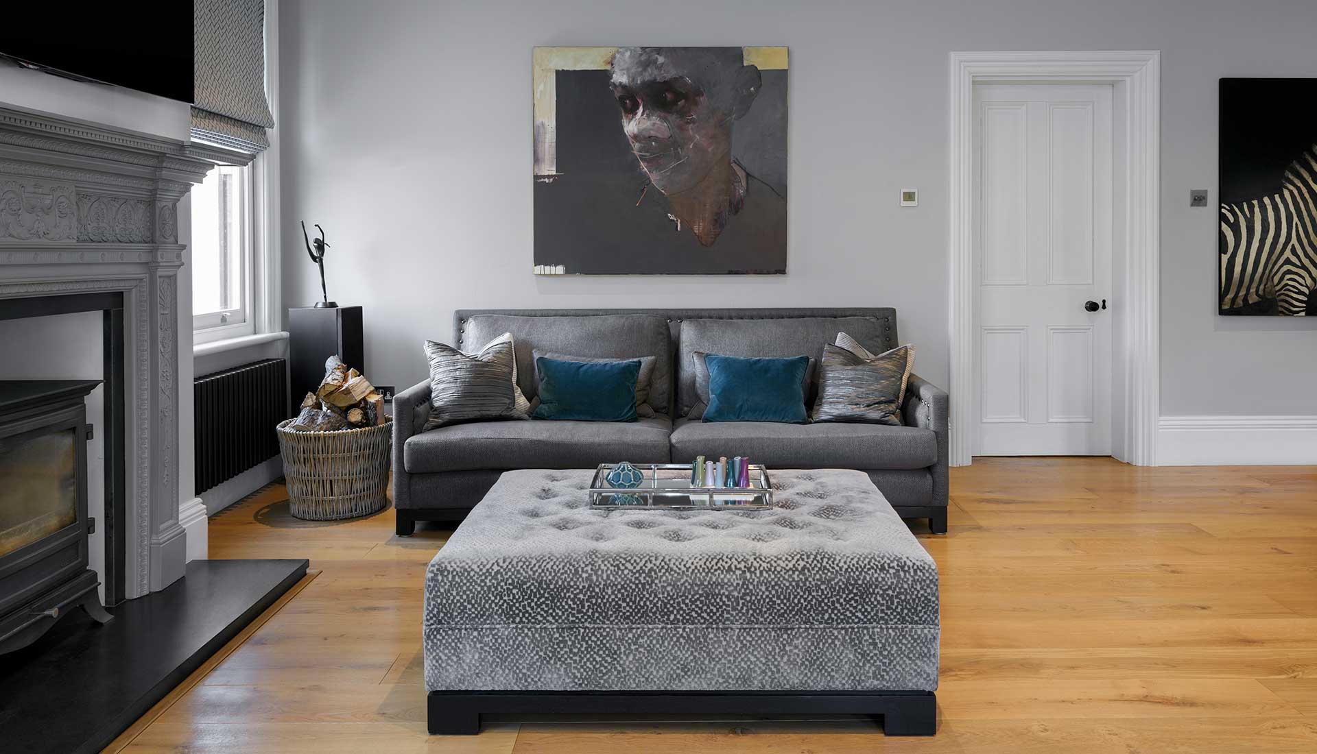 Grey Sofa and Foot Stool with lit fire